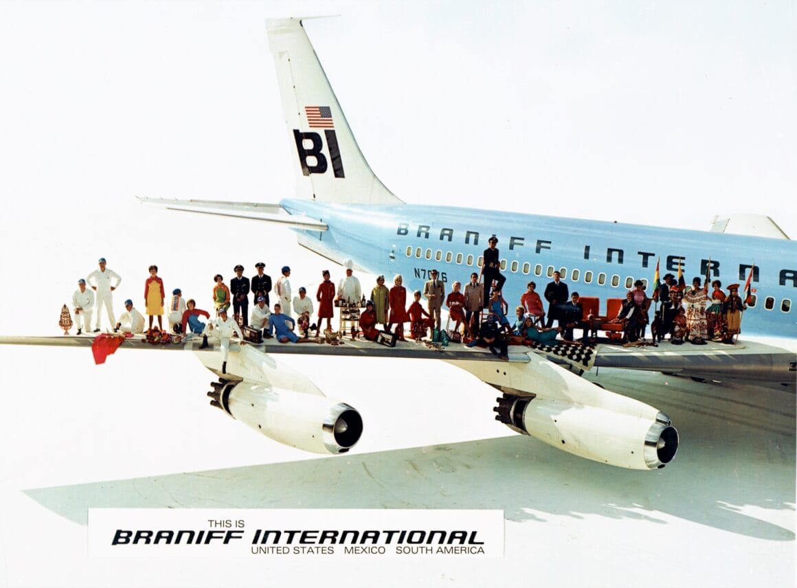 De nombreuses personnes de métiers différents perchées sur l'aile d'un Boeing 707 de Braniff International.
